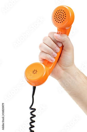 Photo: Hand holding an old orange telephone tube Hand holding an old orange telephone tube