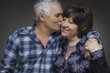 Older couple: elderly man kisses the old woman - love concept