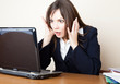 Frightened woman is looking at the laptop screen