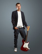 stylish man with guitar looking at camera