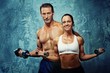 Athletic man and woman with a dumbells.