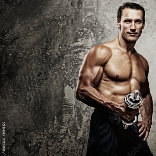Photo: Athletic man and woman with a dumbells. Athletic man and woman with a dumbells.
