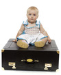 Fun baby sits on the suitcase