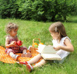 Children reading the book on picnic Children reading the book on picnic