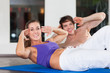 Paar macht Situps in einem Fitnessstudio