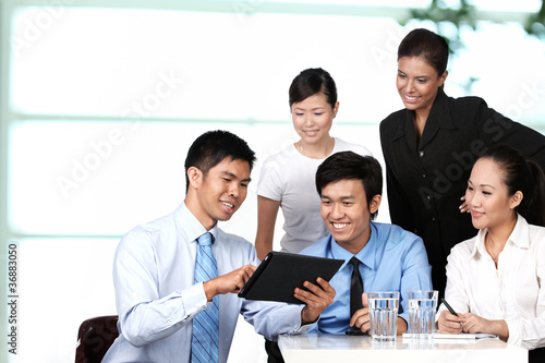Photo: Business colleagues looking at a touchpad Business colleagues looking at a touchpad
