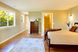 Large bedroom with modern brown bed and green walls.