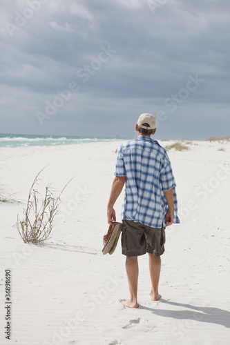 Foto: Man Walking on a Beautiful Beach Man Walking on a Beautiful Beach