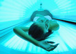 Beautiful young woman tanning in solarium
