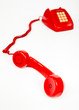 Teléfono rojo descolgado en fondo blanco.