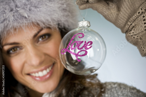 Photo: A young woman holding a glass bauble A young woman holding a glass bauble