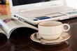 Cup of coffee beside laptop, business concept
