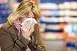Frau mit Taschentuch in Apotheke