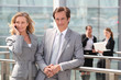 Male and female executives outside conference center