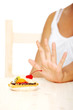 Hand showing stop gesture to cake.