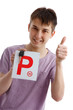 Teen boy holding driver P plates and car key