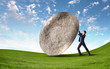 Businessman rolling a giant stone