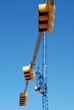 A three traffic light post and a crane in a blue sky A three traffic light post and a crane in a blue sky
