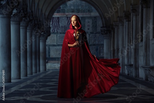 Photo: Beautifiul woman in red cloak outdoors Beautifiul woman in red cloak outdoors