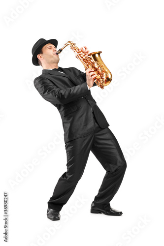 Photo: Portrait of a man in a suit playing on saxophone Portrait of a man in a suit playing on saxophone