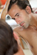Man with hair concern looking at the mirror