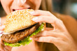 Foto: Frau im Restaurant isst Hamburger Frau im Restaurant isst Hamburger
