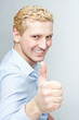 Handsome young man in a blue shirt giving thumbs up. isolate on