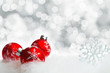 Rote Christbaumkugeln im Schnee