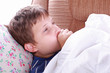 Young ill child coughing in bed