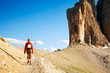 Photo: Young woman with backpack walking through rocky land Young woman with backpack walking through rocky land