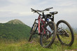 Two bicycles leaning against each other on hilltop