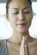 Young woman holding hands in prayer position