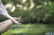 Young woman sitting in lotus position outdoors, cropped