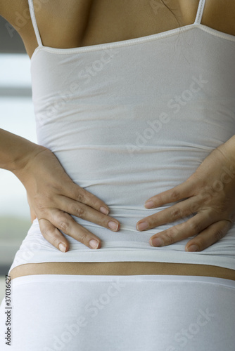 Photo: Woman experiencing lower back pain, cropped Woman experiencing lower back pain, cropped