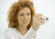 Woman holding up camera, squinting