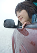 Woman sticking head out of car window in rainy weather