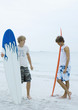 Two surfers standing on beach