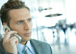 Businessman using cell phone in airport