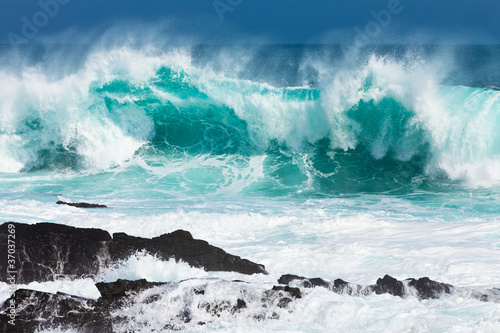 Photo: Turquoise rolling wave slaming on the rocks Turquoise rolling wave slaming on the rocks