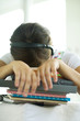 Teen girl resting head on stack of homework