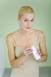 Mother holding bottle of baby powder, smiling at camera