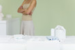 Woman standing in nursery, arms folded, cropped