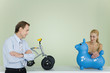 Couple standing by toys, looking at each other, man's arms folded