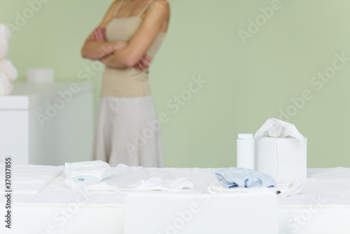 Photo: Woman standing in nursery, arms folded, cropped Woman standing in nursery, arms folded, cropped