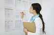 Young woman checking information posted on bulletin board