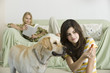Teenage girl offering dog biscuit to pet dog