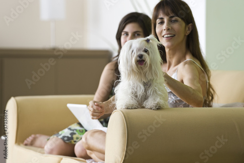 Photo: Woman relaxing with pet dog and teenage daughter Woman relaxing with pet dog and teenage daughter