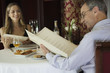Mature couple in restaurant looking at menus