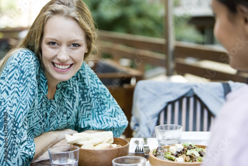 Photo: Young woman with friend at restaurant Young woman with friend at restaurant