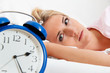 Schlaflos mit Uhr in der Nacht.